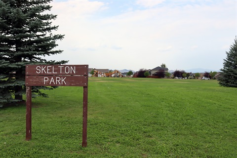 Wood sign, grass and trees at Skelton Park.