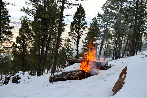 Slash pile burns on Mount Helena in the snow.